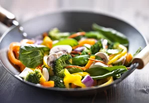 Légumes frais coupés en morceaux dans un grand wok